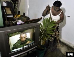 Archivo. Una mujer cubana limpia su casa mientras sigue por la TV la intervención especial de Fidel Castro.